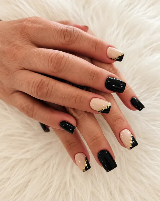 Black and nude manicure with gold tips
